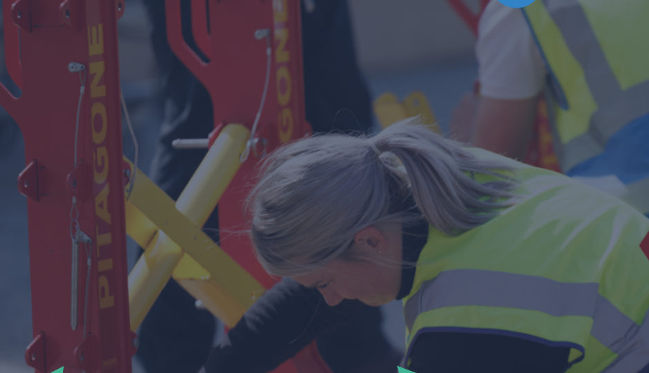 Workers in high-visibility vests install red temporary road barriers labeled ‘Pitagone’ at a construction site, with one person bending to secure equipment; colorful geometric graphics line the bottom and an ‘EP Team’ logo appears in the corner.